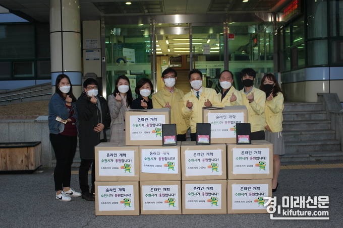 장수석 수원시 정보통신과장(왼쪽 5번째), 김인종 수원교육지원청 경영지원과장(오른쪽 5번째)과 직원들이 태블릿PC를 전달하고 기념촬영을 하고 있다.<사진=수원시>