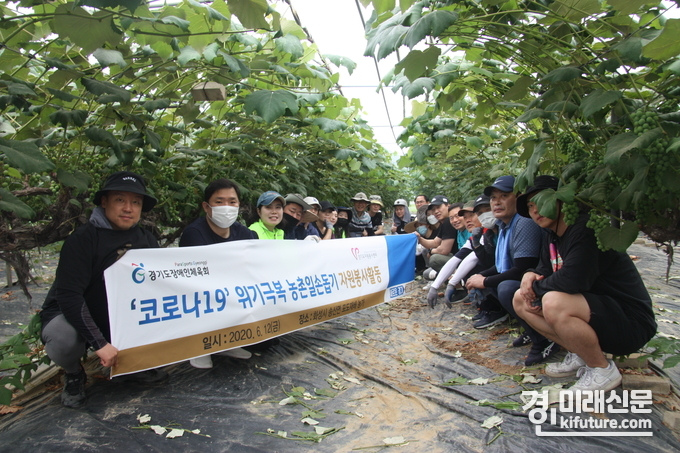 경기도장애인체육회 직원들이 지난 12일 화성시 천등리에 위치한 한 포도농가를 방문해 일손을 돕고 있는 가운데 기념촬영을 하고 있다.<사진=경기도장애인체육회>