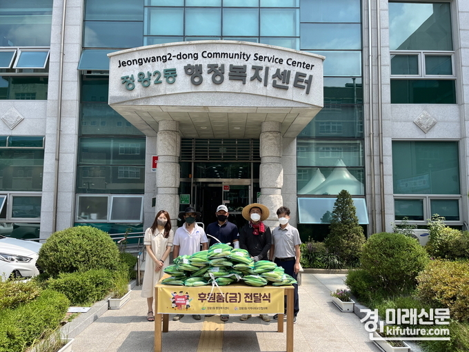너나우리 연합봉사단은 정왕2동에 옥수수를 지원하고 관계자들과 기념촬영을 하고 있다. <사진=시흥시>