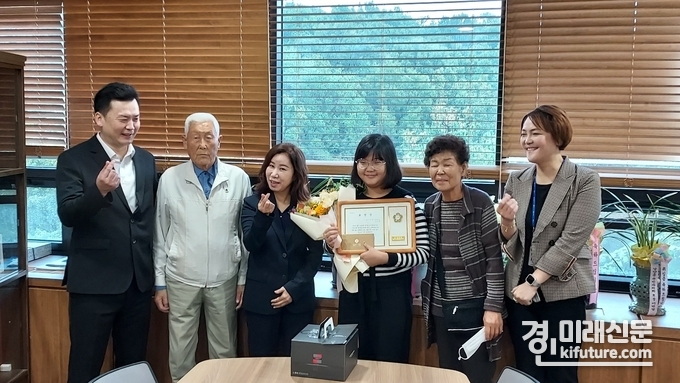 4일 김경희 화성시의회 의장이 김시율 벌말초등학교 학생에게 표창장을 수여하고 관계자 및 가족들(왼쪽부터 김시율 학생 아버지, 외할아버지, 김경희 의장, 김시율 학생, 외할머니, 엄마)과 기념촬영을 하고 있다. <사진=민경호 기자>