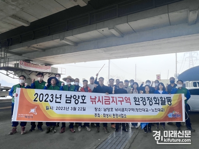 화성시 관계자들이 남양호 환경정화 활동에 참여한 가운데 기념촬영을 하고 있다. <사진=화성시>