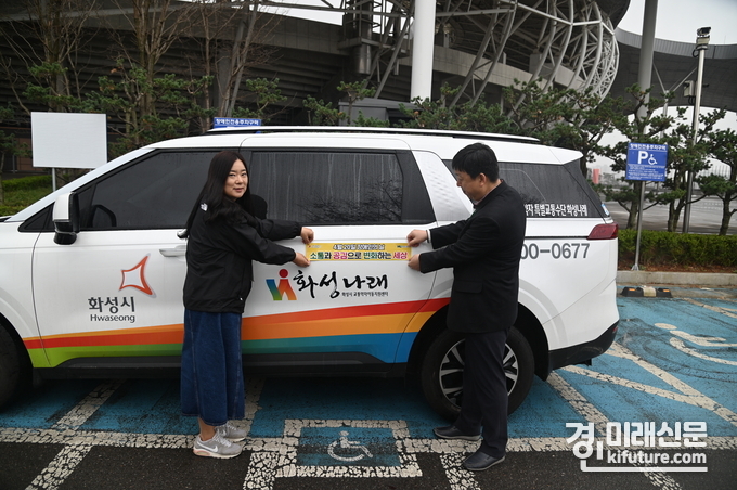 화성도시공사가 장애인 인식개선 펴어를 차량에 부착하고 있다. <사진=화성도시공사>