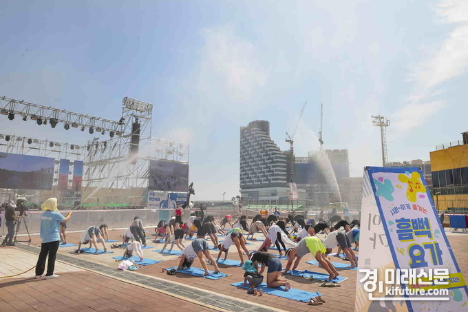 관광객들이 2023년 시흥거북섬해양축제에서 무더위를 시원한 물줄기로 식히는 흠뻑요가에 참여하고 있다. <사진=시흥시>