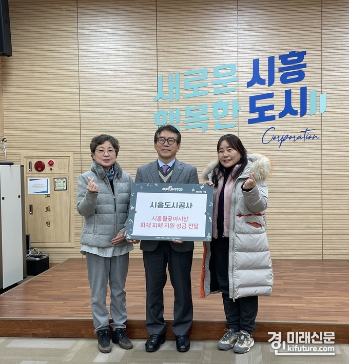 시흥도시공사 관계자가 지난달 30일 시흥 월곶종합어시장 화재 피해 복구 성금을 전달하고 기념촬영을 하고 있다. <사진=시흥도시공사>