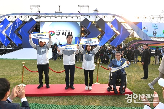 화성특례시 관계자(좌로부터 박종선 화성시체육회장, 정명근 화성시장, 김경희 화성시의회 의장, 이용운 화성시의원)들이 현수막 들고 응원하고 있다. <사진=화성시의회>