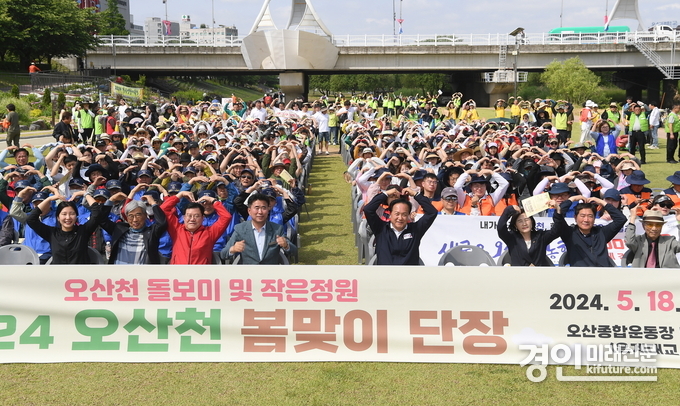 오산시는 오산천 일원에 금계국을 식재하는 등 봄맞이 단장을 하고 기념촬영을 하고 있다. <사진=오산시>