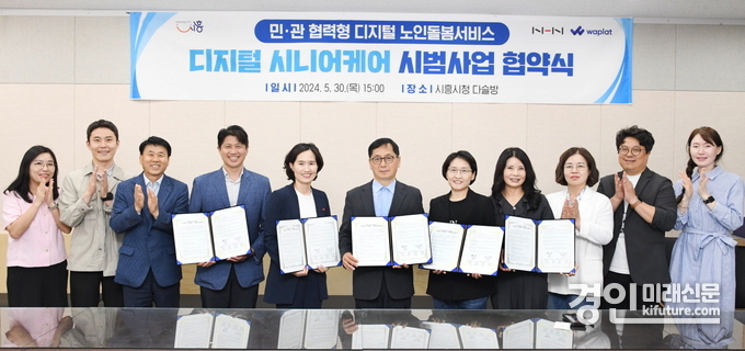 시흥시가 디지털시니어 케어 시범사업 협약식을 개최하고 관계자들과 기념촬영을 하고 있다. <사진=시흥시>
