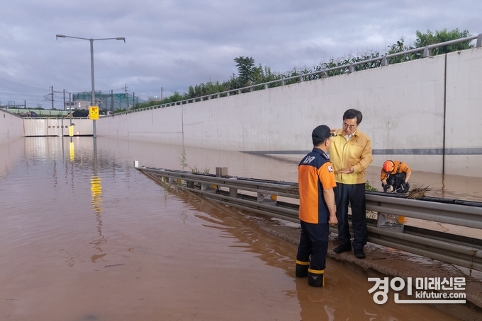 김동연 경기도지사(오른쪽)가 침수된 평택 세교 지하차도에서 소방관계자와 피해복구상황에 대해 얘기를 나누고 있다. <사진=경기도>