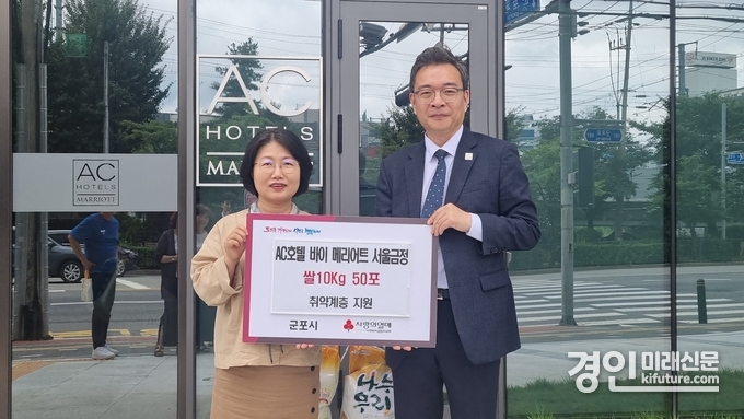 오숙 복지정책과장(왼쪽)이 AC호텔바이 메리어트 관계자와 기념촬영을 하고 있다. <사진=군포시>