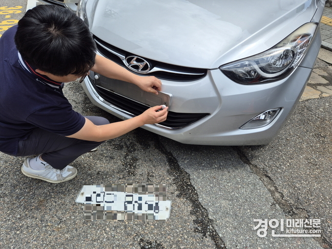 수원시 관계자가 체납차량의 번호판을 영치하고 있다. <사진=수원시>