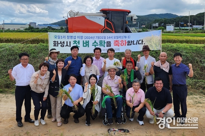 화성시가 첫 벼베기 행사를 진행하고 관계자들이 기념촬영을 하고 있다. <사진=화성시>