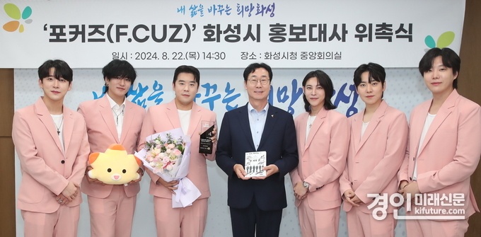 정명근 화성시장(가운데)이 '포커즈'에 홍보대사 위촉패를 전달하고 기념촬영을 하고 있다. <사진=화성시>