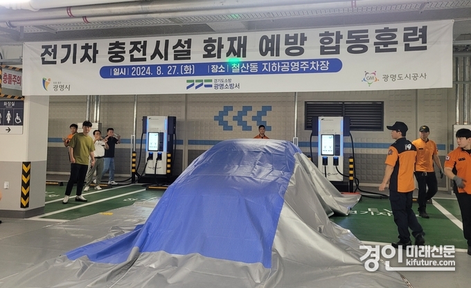 광명시는 지난 8월 27일 철산동 지하공영주차장에서 광명소방서와 전기차 충전시설 화재 예방 합동훈련에서 질식소화포 사용법을 시연하고 있다. <사진=광명시>