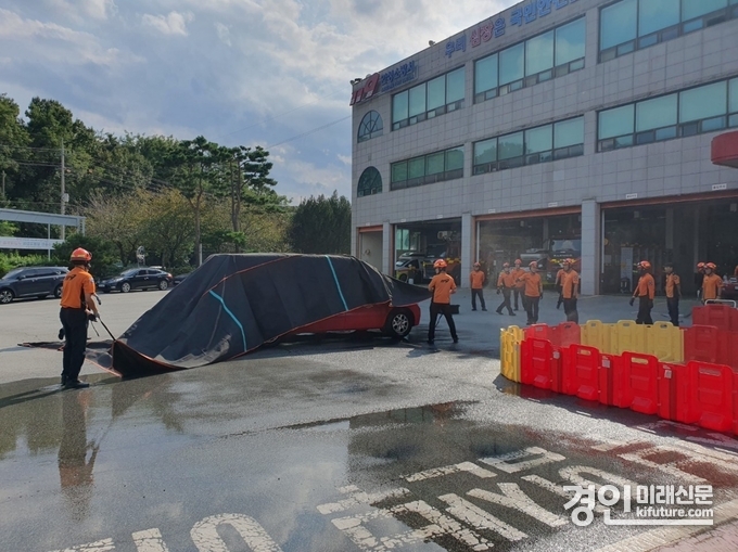안성소방서가 질식 소화덮개를 이용한 전기차 화재 진압 훈련을 하고 있다. <사진=안성소방서>