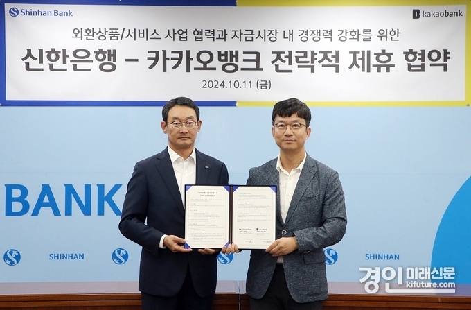 지난 11일 서울시 중구 신한은행 본점에서 진행된 ‘신한은행-카카오뱅크 전략적 제휴 협약식’에서 신한은행 김광수 고객솔루션 그룹장(왼쪽)과 카카오뱅크 이형주 최고비즈니스책임자(오른쪽)가 협약서를 체결하고 기념촬영을 하고 있다. <사진=신한은행>