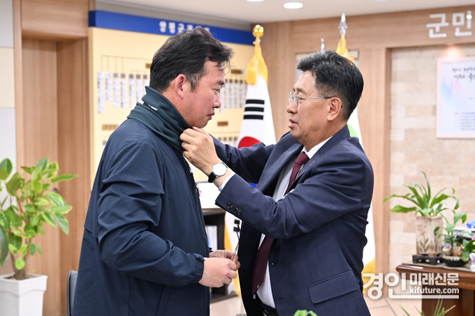 전진선 양평군수(오른쪽)이 현업종사원에게 방한물품을 입혀주고 있다. <사진=양평군>