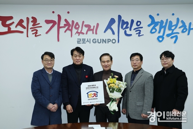 하은호 군포시장(왼쪽 2번째)이 군포국민체육센터 장애인친화최우수시설표창을 수상하고 관계자들과 기념촬영을 하고 있다. <사진=군포시>