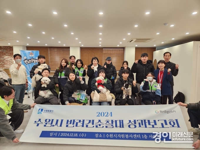 수원시 반려견 순찰대 성과보고회에 참석한 견주와 반려견이 기념촬영을 하고 있다. <사진=수원시>