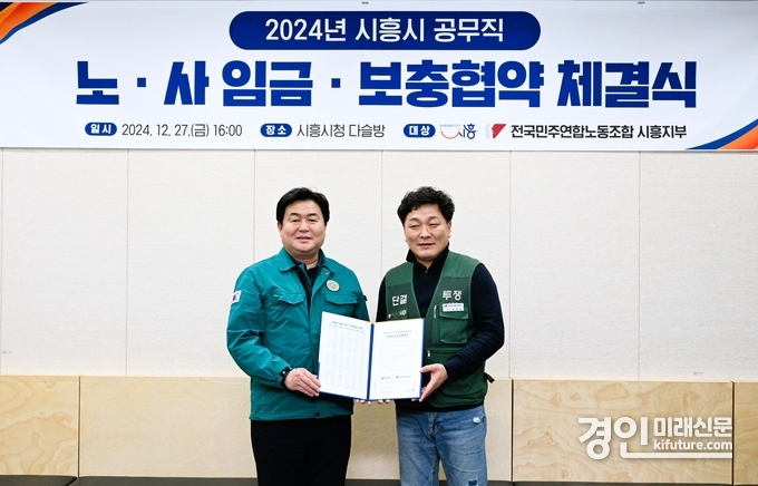 임병택 시흥시장(왼쪽)과 김기범 전국민주연합노동조합 시흥지부장이 지난 27일 노·사 임금·보충렵약을 체결하고 기념촬영을 하고 있다. <사진=시흥시> 