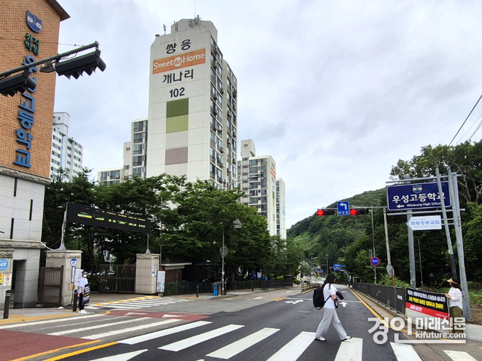 우성고등학교 학부모들이 의왕우리교회에 학교 운영 및 재정의 투명성 확보 등을 요구하는 시위를 하고 있는 가운데 한 학생이 횡단보도를 건너고 있다. <사진=민경호 기자>