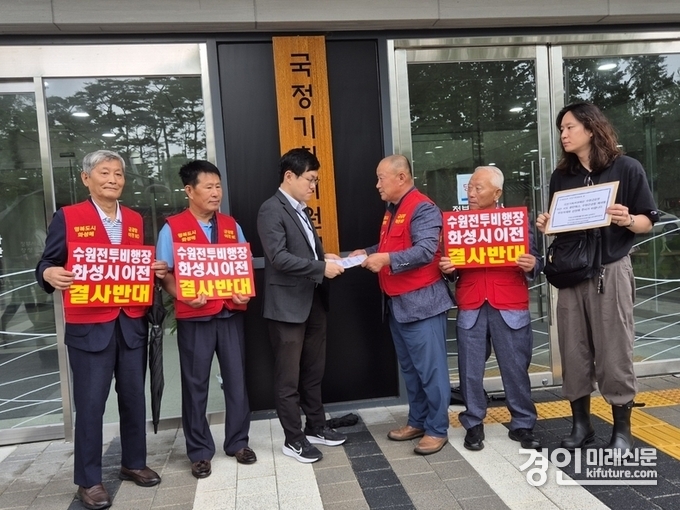 수원전투비행장 화성이전 반대 범시민대책위원회 이상환 상임위원장이 18일 수원군공항이전 TF 및 6자협의체 구성 건의 반대 입장 결의문을 발표하고 반대의견서를 국정기획위원회 관계자에게 전달하고 있다. <사진=독자제공>