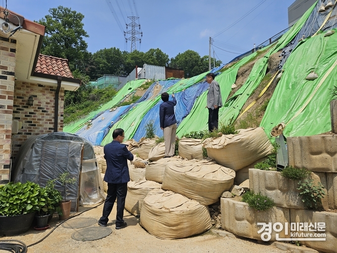 화성시 시민옴부즈만이 부도난 공장부지에 방치된 법면 현장을 살피고 있다. <사진=화성시>