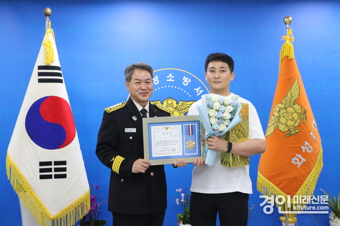 화성소방서가 구조활동에 큰 기여를 한 박혜욱(오른쪽)씨에게 유공표창을 수여하고 기념촬영을 하고 있다. <사진=화성소방서>