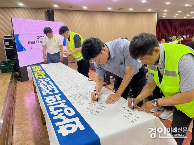 화성시 관내 공사현장 관계자 및 안전관리자들이 30일 무재해 결의대회에서 무재해 결의문 현수막에 안전기원 문구를 적고 있다. <사진=화성시>