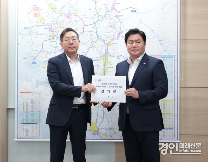 임병택 시흥시장(오른쪽)이 최용택 LH 광명시흥사업본부장에게 건의문을 전달하고 있다. <사진=시흥시>