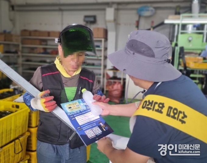 화성시 관계자가 12일 근로자에게 온열질환 예방 안내문과 얼음물을 전달하고 있다. <사진=화성시>