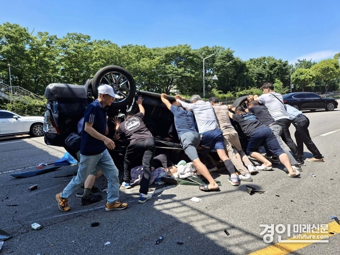 시민들이 차량 전복 사고 피해자를 구하고 있다. <사진=안산시>
