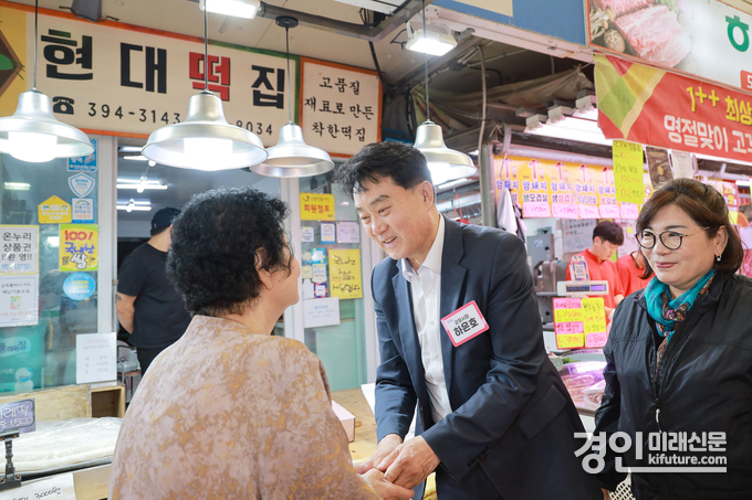 하은호 군포시장(가운데)이 전통시장에서 시민의 손을 잡아주고 있다. <사진=군포시>