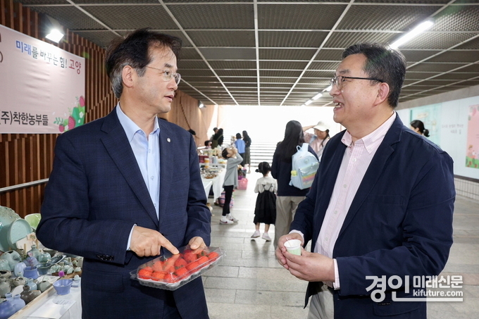 이동환 고양시장(왼쪽)이 마두스마트팜에서 재배된 딸기를 들고 관계자의 설명을 듣고 있다. <사진=고양시>