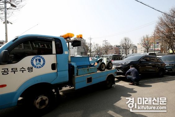 수원도시공사 관계자가 거주자우선주차 구역의 불법 주차 차량을 견인하고 있다. <사진=수원도시공사>
