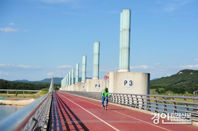 남한강 보에 설치된 자전거 도로에 시민이 자전거를 타고 건너고 있다, <사진=여주시>