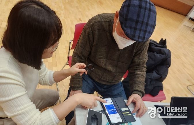 화성시 관계자가 어르신에게 AI · IOT 건강관리에 대해 설명하고 있다. <사진=화성시>