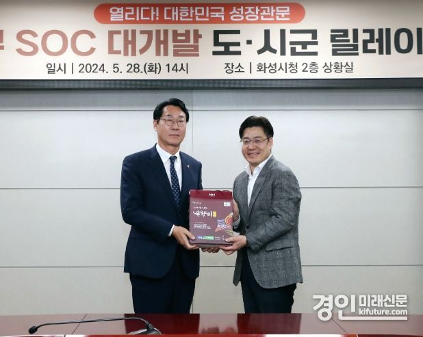 정면근 화성시장(왼쪽)이 경기 서부 SOC 대개발 구상 시·군 릴레이 현장 간담회에 참석한 오병권 경기도 행정1부지사에세 수향미를 선물하고 있다. <사진=화성시>