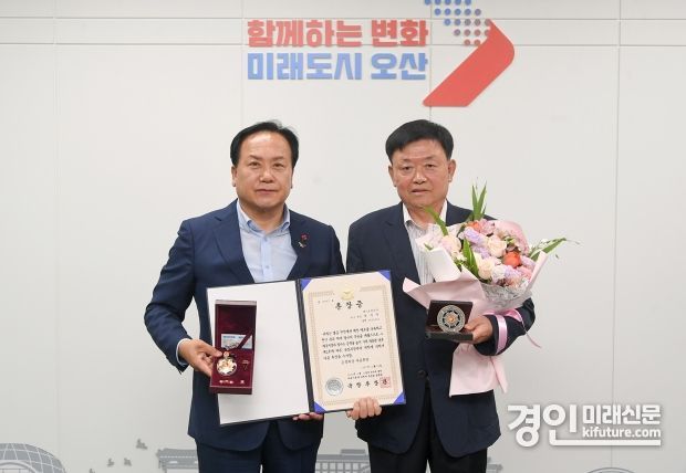 이권재 오산시장(왼쪽)이 6·25참전유공자 유가족에게 ‘금성화랑 무공훈장’을 전수하고 기념촬영을 하고 있다. <사진=오산시>